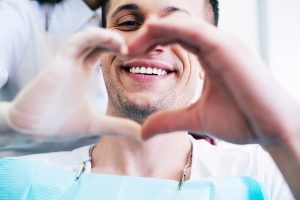 Man signaling a heart in color, Foundations of Health Dental Care